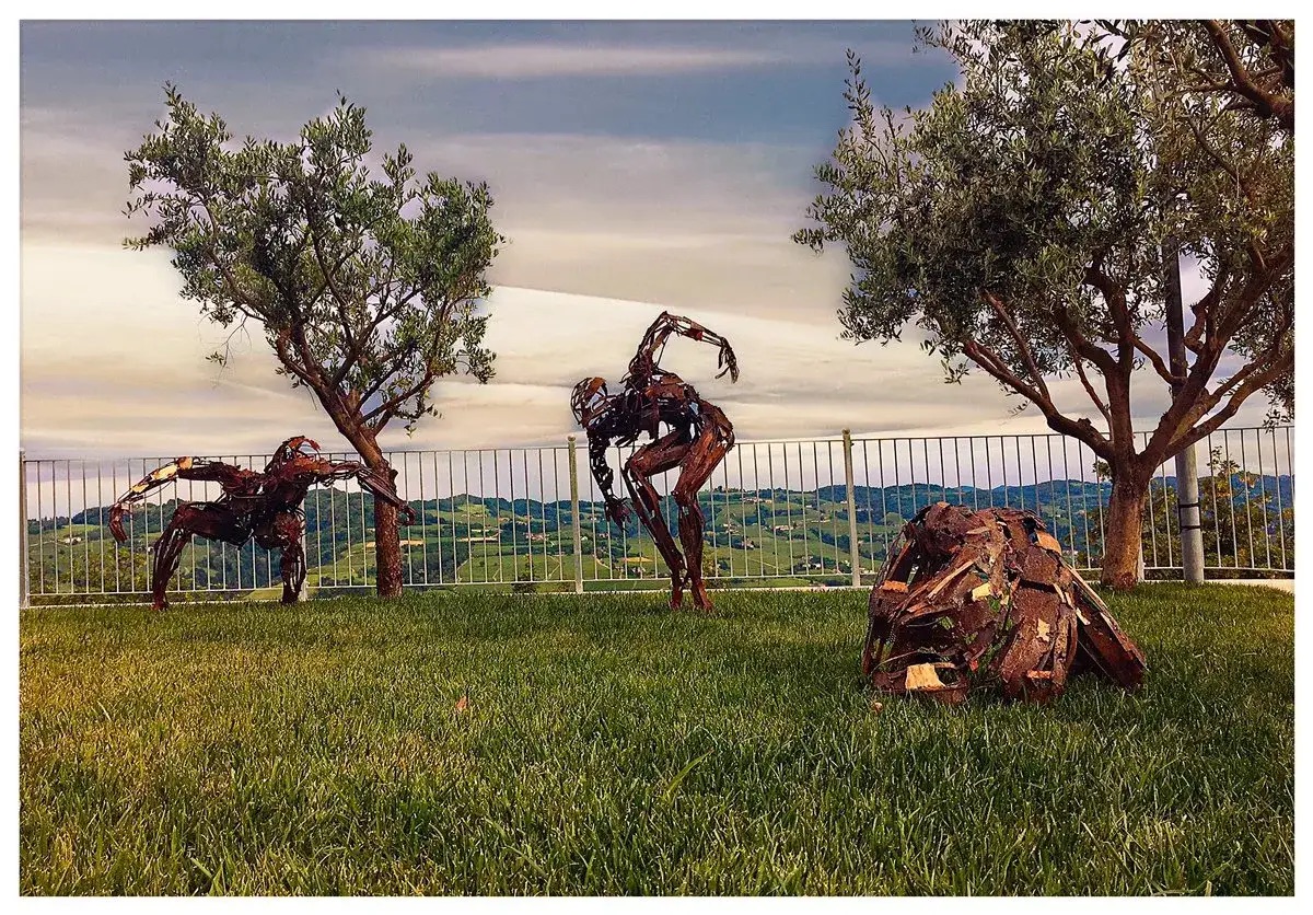 Sculture in metallo tra gli ulivi con vista sulle colline, Museo a Cielo Aperto di Camo